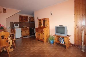 ein Wohnzimmer mit einem TV und einer Küche in der Unterkunft Apartment Da Renza in Bormio