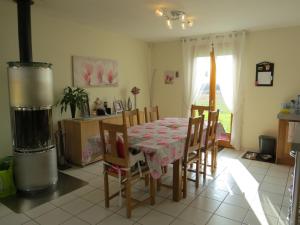 uma mesa de jantar e cadeiras numa cozinha em Chambre d'hôtes La Clé du Bonheur em Manthelon