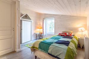 a bedroom with a bed in a room with wooden walls at La Maison Bizienne Guérande in Guérande