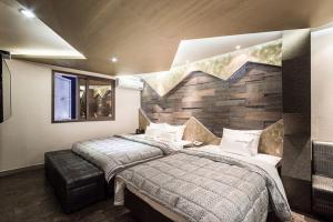 sypialnia z dużym łóżkiem i kamienną ścianą w obiekcie Hotel JUNE Haeundae w Pusanie
