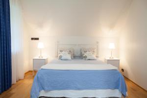 a bedroom with a blue bed with two lamps at Toila Valgevilla Apartments in Toila