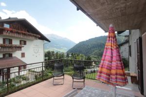 a patio with two chairs and an umbrella on a balcony at Apartment Da Renza in Bormio