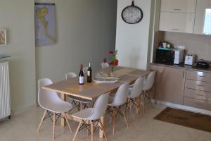 a kitchen with a wooden table and white chairs at Aquarius House in Agios Georgios