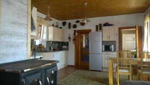 a kitchen with white cabinets and a table and a refrigerator at Chalupa u studny in Lukov