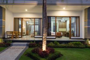 a house with a palm tree in the middle of a yard at Semabu Hills Hotel Nusa Penida in Nusa Penida