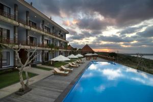 a hotel with a swimming pool with chairs and umbrellas at Semabu Hills Hotel Nusa Penida in Nusa Penida