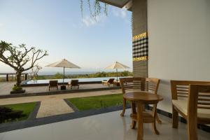 a balcony with a table and chairs and a view at Semabu Hills Hotel Nusa Penida in Nusa Penida