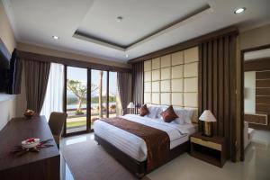 a bedroom with a large bed and a large window at Semabu Hills Hotel Nusa Penida in Nusa Penida