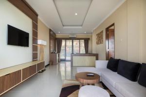 a living room with a couch and a tv at Semabu Hills Hotel Nusa Penida in Nusa Penida