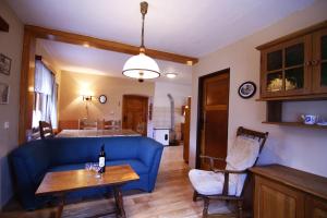 a living room with a blue couch and a table at Ubytovani U Lavky in Suchovršice +21 photos