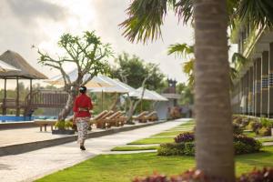a woman walking down a sidewalk in a park at Semabu Hills Hotel Nusa Penida in Nusa Penida