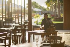 a man sitting at a table in a restaurant at Semabu Hills Hotel Nusa Penida in Nusa Penida