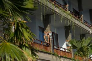 a woman standing on a balcony of a building at Semabu Hills Hotel Nusa Penida in Nusa Penida
