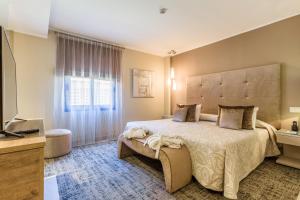 A bed or beds in a room at Lago Garden Apart-Suites & Spa Hotel