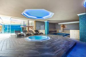 Cette grande chambre dispose d'une piscine avec un grand plafond. dans l'établissement Lago Garden Apart-Suites & Spa Hotel, à Cala Ratjada