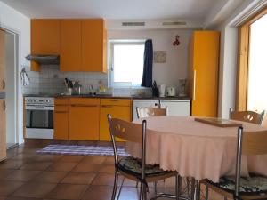a kitchen with orange cabinets and a table with chairs at Casa Fiorella in Locarno