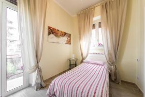 Tivoli Charming Houses - Domus Aefula and Domus Albula في تيفولي: غرفة نوم بسرير وبطانية مخططة