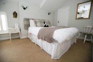 a bedroom with a white bed with a dog sitting on it at The Ivy House in Chalfont Saint Giles