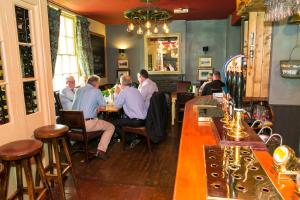 eine Gruppe von Personen, die in einer Bar in einem Restaurant sitzen in der Unterkunft The Ivy House in Chalfont Saint Giles