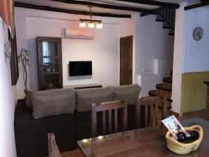 sala de estar con sofá y TV en Casas San Cristóbal by CasaTuristica, en Jimera de Líbar