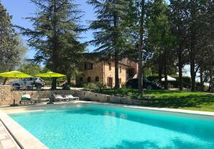 a swimming pool in front of a house at Poggio Cantarello Vacanze in Chiusi
