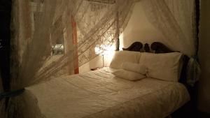 a bedroom with a bed with white sheets and curtains at Natone in Hobart