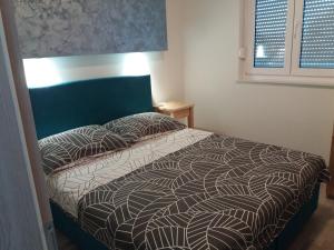 a bedroom with a bed with a black and white comforter at Apartments Nešić Peroj in Fažana