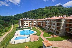 an aerial view of an apartment complex with a swimming pool at Apartamento Jardines del Sella in Cangas de Onís