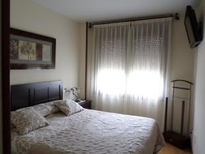 a bedroom with a white bed and a window at Apartamento Jardines del Sella in Cangas de Onís +14 photos