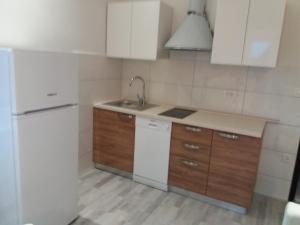 a kitchen with a white refrigerator and wooden cabinets at Apartments Nešić Peroj in Fažana
