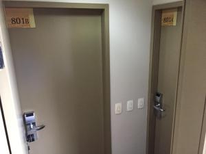 dos puertas en una habitación con letreros numerados en CASA DEL MAR - Apartamento na Beira da Praia, en Río de Janeiro