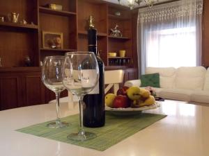 - une bouteille de vin et 2 verres à vin sur une table dans l'établissement Casa al Trevio, à Tivoli
