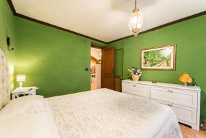 um quarto com paredes verdes e uma cama branca em Casa al Trevio em Tivoli