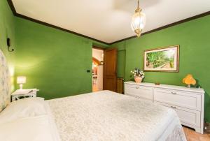 チボリにあるCasa al Trevioの緑の壁のベッドルーム(白いベッド付)
