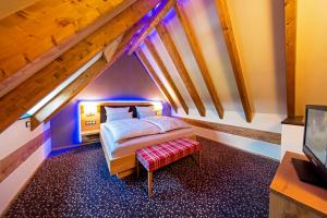 a bedroom with a bed and a bench in a attic at Landhotel Repetal in Attendorn