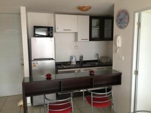 cocina con encimera y nevera en Pronejoet Departamentos La Herradura, en Coquimbo