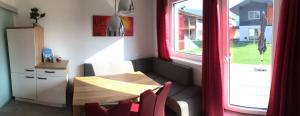 a small table and chairs in a room with a window at Appartement Schusternagele in Amlach +23 photos