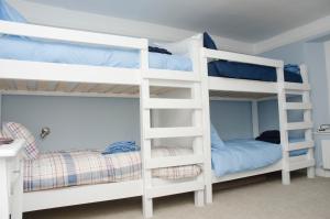 two white bunk beds in a room with a bed at The Sun Inn in Penrith