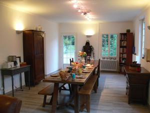 a dining room with a large wooden table with benches at Le Clos des Archers in Laveyssière