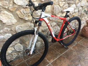 una bicicletta rossa e bianca parcheggiata contro un muro di pietra di villa vista mare spiaggia privata a Scopello