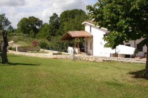 ein kleines weißes Haus mit einem Rasenhof in der Unterkunft Agriturismo Casale Sera in Fontana Liri