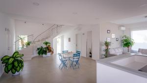 a white living room with a table and chairs at Villa Patrizia Selinunte in Marinella di Selinunte