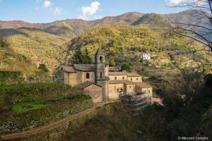 an old church on a hill with mountains in the background at Teré Ceriana Affittacamere in Ceriana