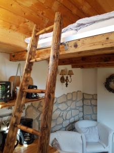 uma cama alta num quarto com uma parede de pedra em Wohnen im Hühnerhaus em Thale