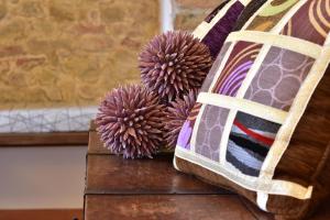 two flowers sitting on a table next to a pillow at Villa San Michele in Barberino di Val dʼElsa