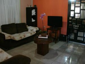 sala de estar con sofá y TV en Gardenia House, en Foz do Iguaçu