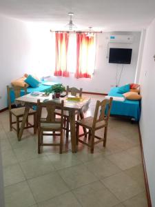 sala de estar con mesa, sillas y sofá en Hermoso Departamento Céntrico en Villa Carlos Paz