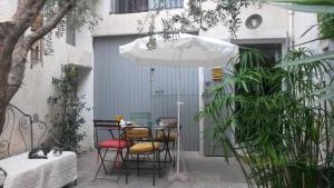 a table with chairs and an umbrella in a courtyard at Alheuredusud in Violès +16 photos