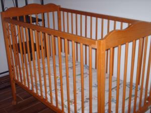 a wooden crib with a mattress in a room at Quinta da Bunheira in Rogil