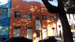 un edificio naranja con un árbol delante de él en Mangue Oranje Hostel, en Recife